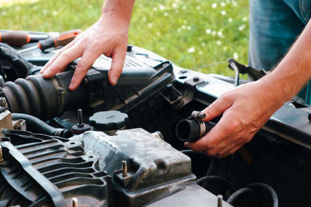 Auto mechanic working on car engine in mechanics garage. Repair service. Close up of car mechanic...