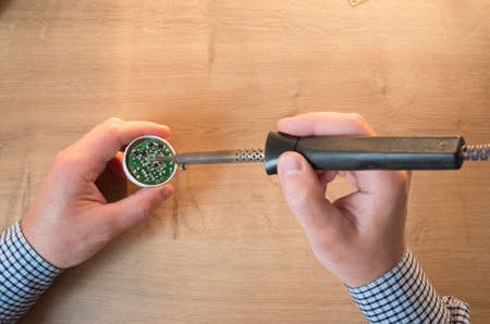 man repairing a led lamp with a soldering iron