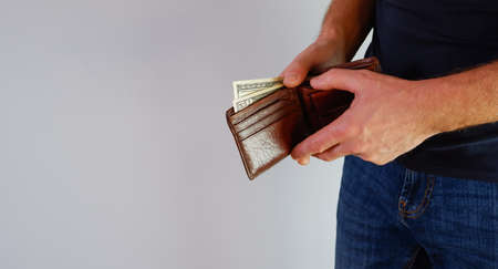 Hand holding a banknote in wallet for financial, accounting and saving money concept. Person holding...