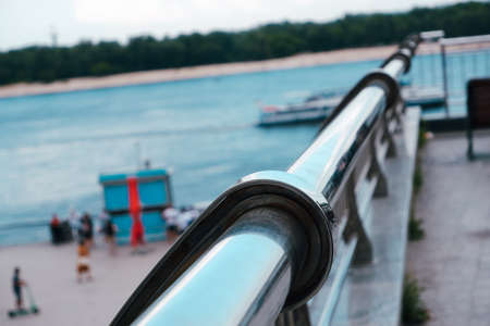 Steel railings fencing on the river embankment in the city. Shiny chrome metal fencing and railingsの写真素材