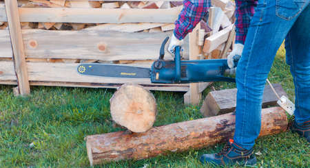 Close-up of woodcutter sawing chain saw. Chainsaw bar and cutt. Woodcutter saws tree with chainsaw...