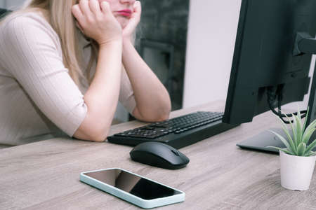 Tired woman at the computer. remote work. selective focus. Businesswoman holding her head in front of a PCの写真素材