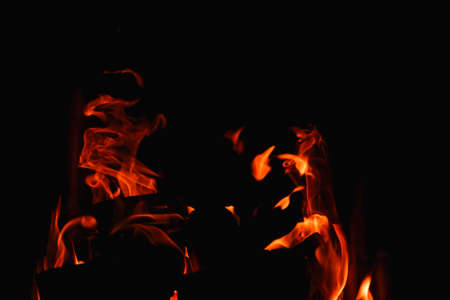 Burning firewood and coals in a stone stove. Brick oven on wood. Long tongues of flame of burning...