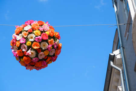 Decoration ball of bright flowers over the street of the old city. the beautiful alleyの写真素材