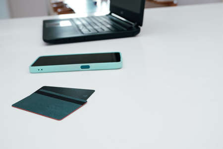Online shopping and e-payment concept. Laptop, cellphone and credit card for online shopping on a white table. Online payment, digital banking. modern interior.の写真素材