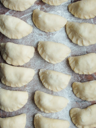 cooking. Dumplings with cottage cheese. Preparation dumplings on a wooden board. Raw dumplings with cheese filling prepared for cooking on a wooden board, close-up view.の写真素材