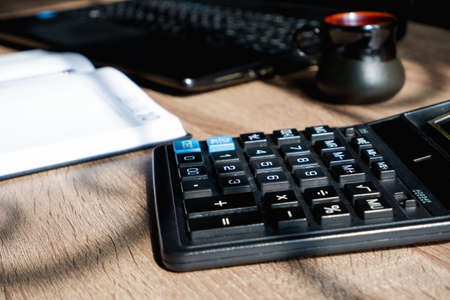 Office desk of startup businessman near the window with a laptop, books and a calculator. Low Angle...