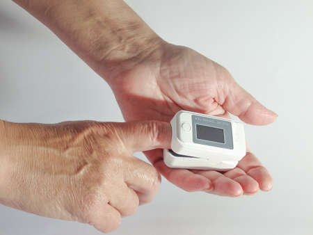 Woman Measuring Oxygen Level in The Blood with Pulse Oximeter. Woman hand with pulse oximeter and...