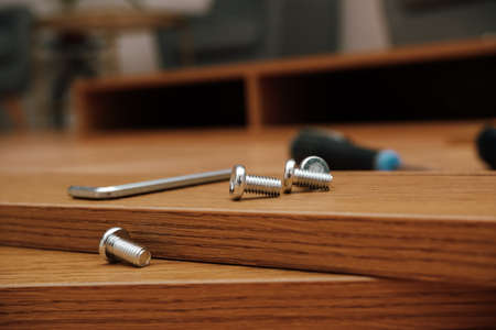 Assembly of furniture, the different parts and pieces of furniture arranged on the wooden floor. DIY...