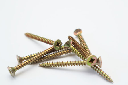 A bunch of yellow screws on a white background. yellow construction screws on white, side view, copy...