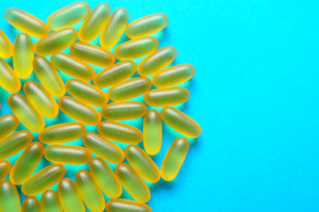 Fish oil omega 3 gel capsules on blue background with copy space. Healthcare, vitamins, supplements...