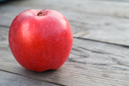 Red ripe apple on a rustic gray wooden boards. Apple close-up on a gray table against a background of boards. copy spaceの写真素材