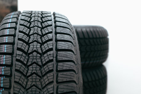 Stack car wheel winter tires isolated. Place for text Close-up of a winter tire tread with a strip...
