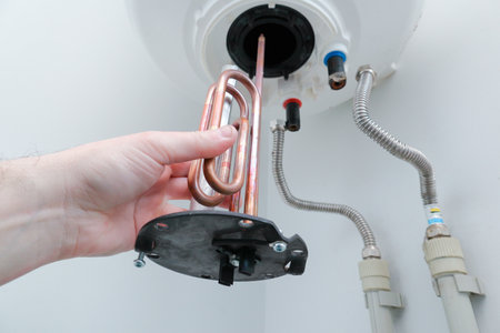 Man's hand putting a new water heater in a boiler.の写真素材