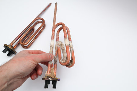 Hand holding damaged boiler heater on a white background with new heater.の写真素材
