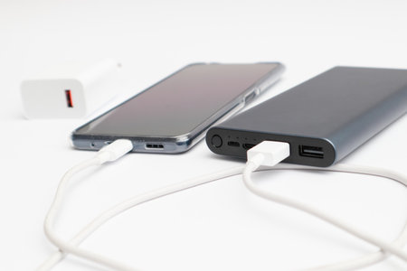 Power bank and smartphone on white background.