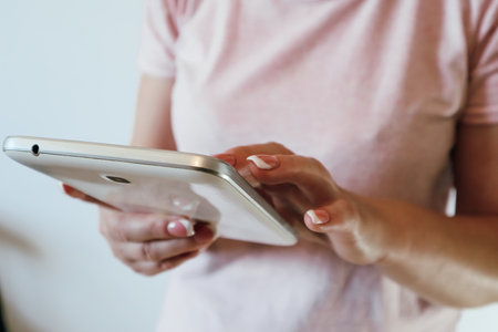 Closeup shot of a woman typing on a digital tablet. Woman hand holding and pointing on electronic...
