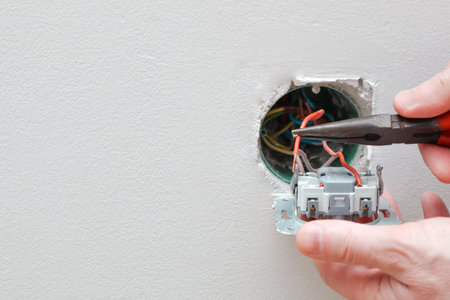 An electrician is replacing a wall switch. A DIY project concept. High voltage danger. Electrician repairing wall light switch panel.の写真素材