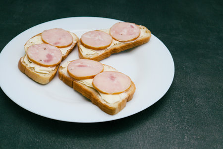 Sandwiches with sausage on a white plate. Breakfast sandwich with sliced sausageの写真素材