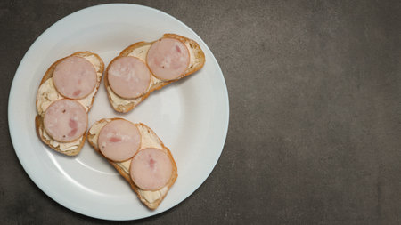 Sandwiches with sausage on a white plate. Breakfast sandwich with sliced sausage