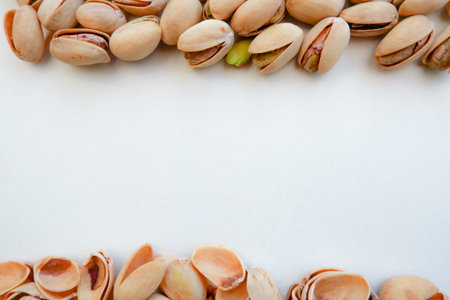 A pile of Pistachio nuts and nutshell on a white background. Pistachios background, place for text.