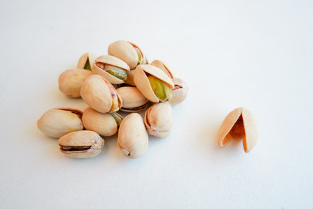 A pile of Pistachio nuts and nutshell on a white background. Pistachios background, place for text.の写真素材