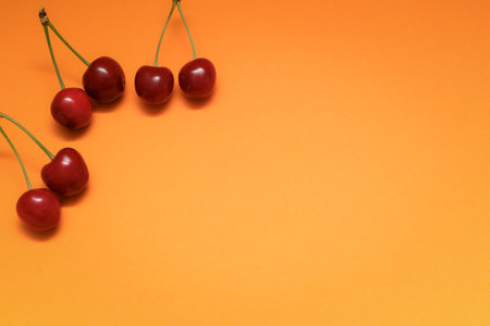 Concept of fresh summer food - delicious cherry. Red sweet cherry berry on a orange background. cherry. fresh sweet cherryの写真素材