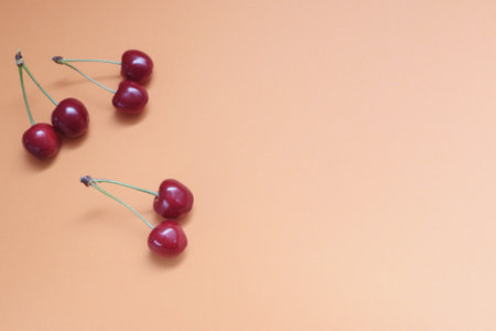 Concept of fresh summer food - delicious cherry. Red sweet cherry berry on a orange background. cherry. fresh sweet cherryの写真素材