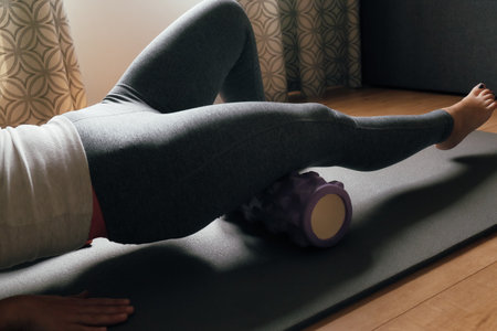 Caucasian woman using a massage foam roller. Using Foam Roller for Muscle and Fascia Massage. Physical therapy and training stretch conceptの写真素材