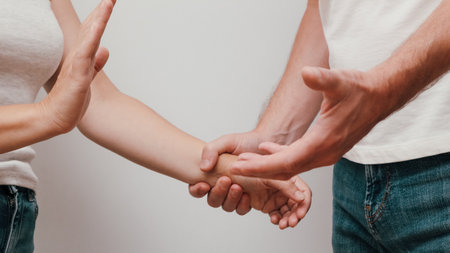 Young Couple with Communication Problems. Man holding female hand in the act of violence. Aggressive relationship concept isolated on white.の写真素材