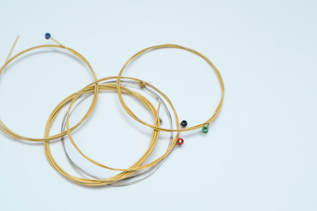 Twisted new guitar strings on white background. Brand new acoustic guitar strings. Place for text.の写真素材