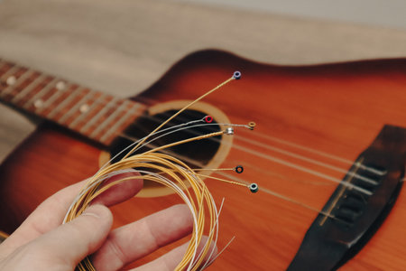 The musician replace the new guitar strings. The man's hand holding new music strings.