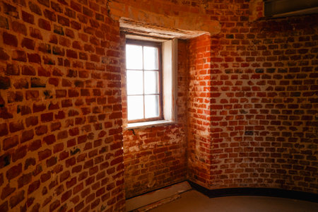 Window on round red brick wall. Interior with red brick wall, big window. Loft industrial grunge interior.の写真素材