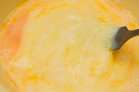 Raw scrambled egg with milk. Cooking omelette with sausage.の写真素材