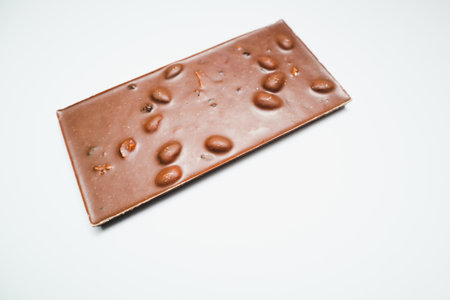 Milk Chocolate bar pieces with nuts on white background. Selective focus.