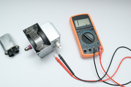 New magnetron and capacitor spare parts for microwave oven. Diagnostics repair of microwave oven.