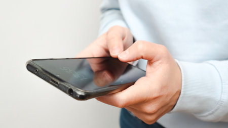 Anonymous woman using her mobile phone. A hand holding a modern smartphone, online, wi-fi, internet,...