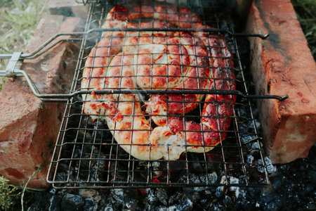 BBQ spiral sausage from pork and beef meat on a grill. Delicious grilled sausage. Spirals sausage grilling on a BBQ over hot flaming coals and smoke.の写真素材