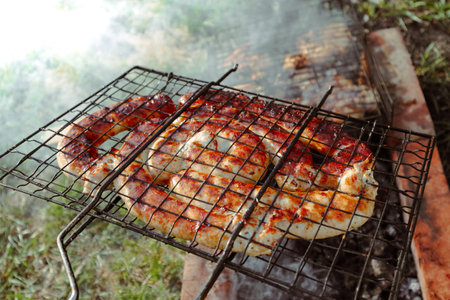 BBQ spiral sausage from pork and beef meat on a grill. Delicious grilled sausage. Spirals sausage grilling on a BBQ over hot flaming coals and smoke.の写真素材