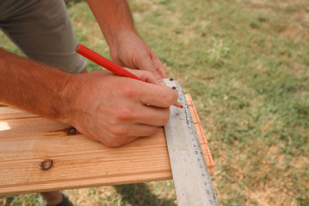 Cropped image of male carpenter marking on plank in workshopの写真素材