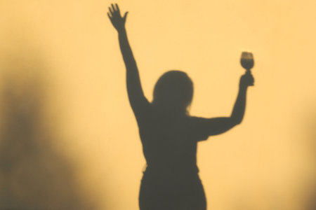 Woman holding glass of wine. Shadow Silhouette of female holding wine. Woman having fun on a partyの写真素材