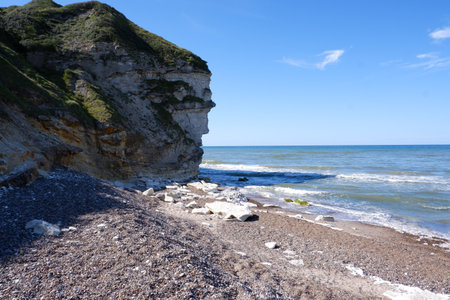 Stone Coast of the Northern Sea made of small cobblestones. Stones on the beach. Pebbles on the coastline.の写真素材