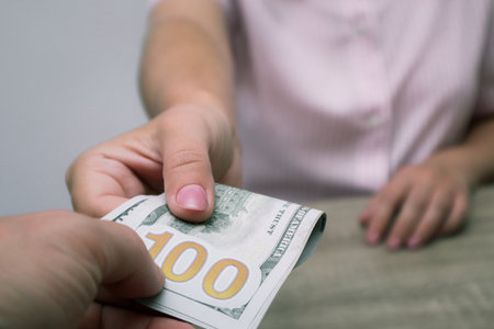 Hand Giving Money. Cash turnover. Man gives banknotes to woman. Dollars Close-up of hands with cash.の写真素材