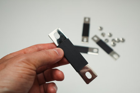 Man's hand with copper bus bar for Lithium Phosphate lifepo4 prismatic cell battery. Battery...