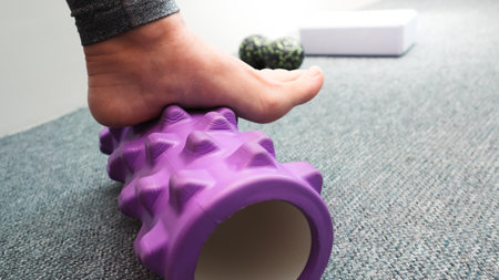 Female legs with roll small sports ball. Roller massager, self massage and healthy lifestyle. Myofascial relaxation of the muscles of the footの写真素材