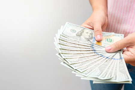 Woman hands holding us dollar bills. Credit and debt concept with copy space. Woman with dollars in her hands.の写真素材