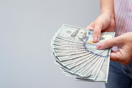 Woman hands holding us dollar bills. Credit and debt concept with copy space. Woman with dollars in her hands.の写真素材