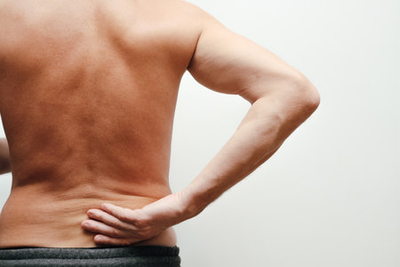 Male holding hand to point of back pain. Senior man having back painの写真素材