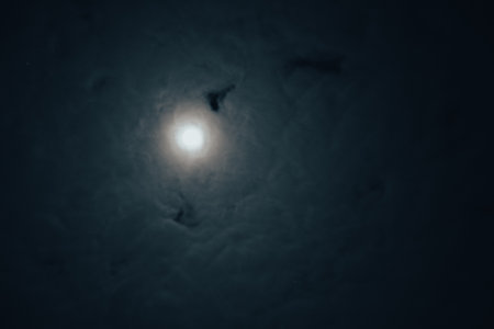 Full moon astral sky with milky clouds. Moon on Cloudy night. Dramatic clouds in mystic moonlight. Full moon illuminating a dark, cloudy night skyの写真素材
