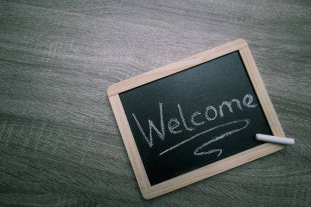 Welcome sign handwritten on the blackboard. Blackboard with text welcomeの写真素材